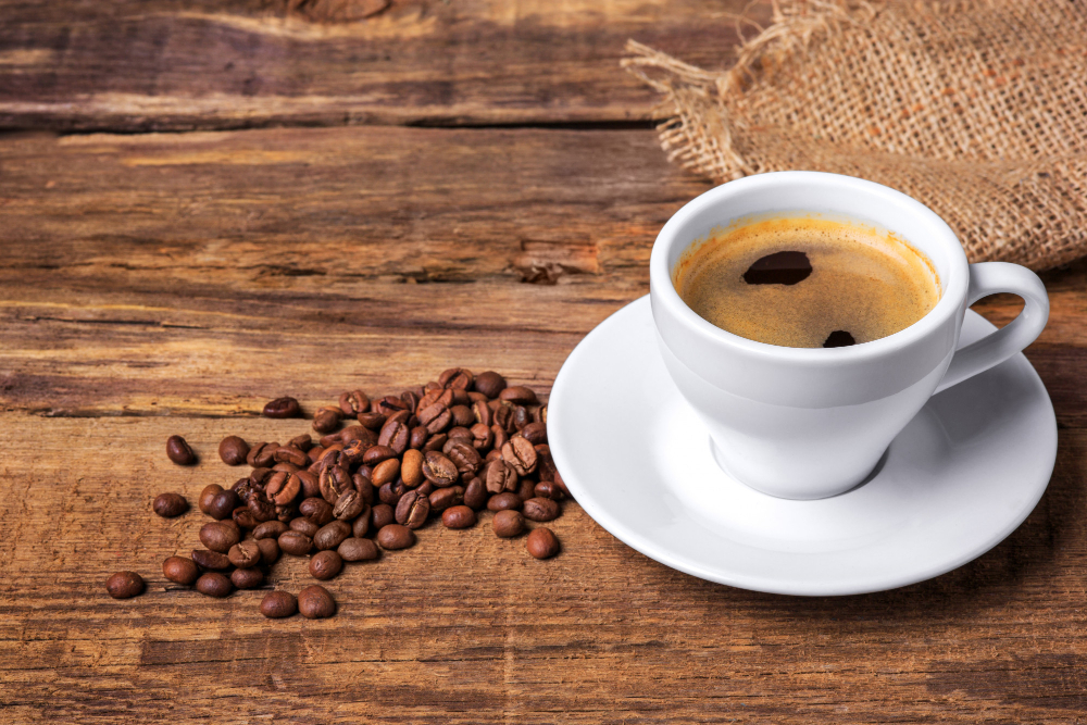 Como fazer Café na Cafeteira Elétrica? 5 xicara de cafe em uma mesa de madeira parede escura